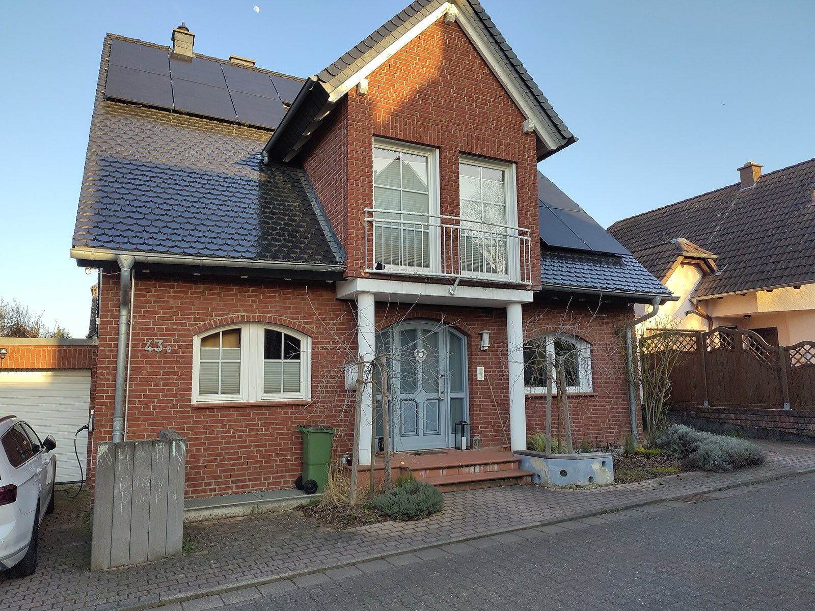 Wohnhaus mit Solaranlage und Fahrzeug am Stellplatz