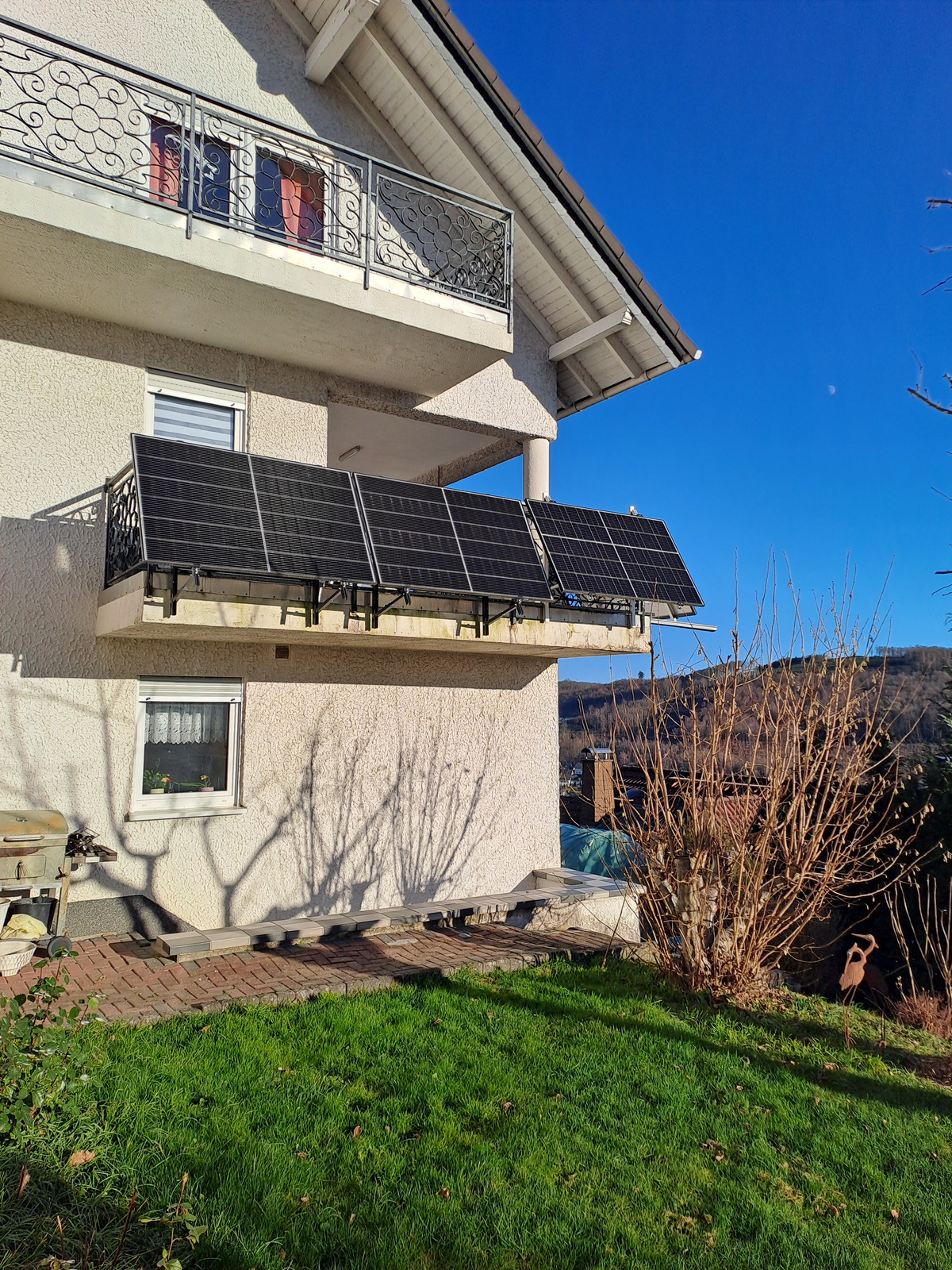 Vier Solarmodule an einem Balkon eines Wohnhauses