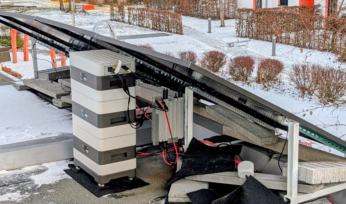 BK-Speichersystem neben Solarmodulen auf einer Terrasse im Winter