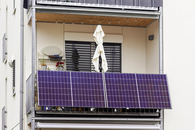 Zwei Solarmodule an einem Balkon eines Mehrfamilienhauses
